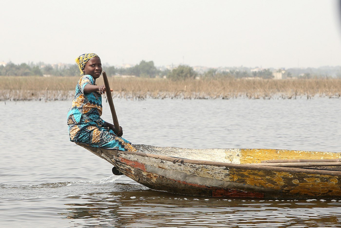 Femme debout sur une pirogue sur le lac Nokoué